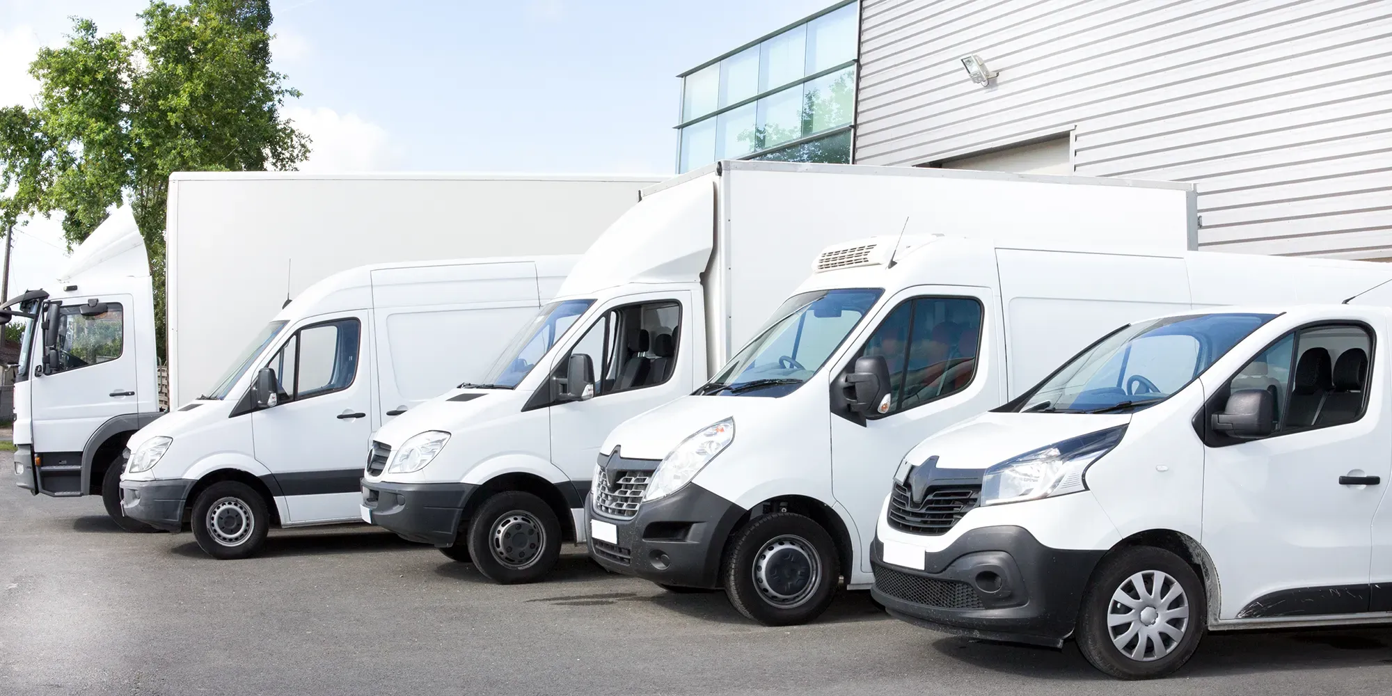 Adobe Stock 196873579 Several cars vans trucks parked in parking lot for rent or delivery copy